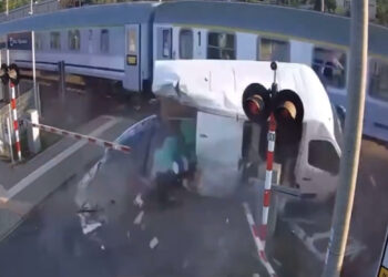 Motorista de van avança sinal vermelho, fica preso entre as cancelas e é atingido por trem na Polônia