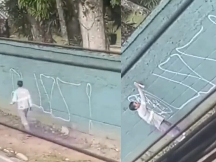 Homem com uniforme da Equatorial é flagrado pichando muro em Belém