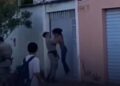 Policial tira mulher do chão pelo pescoço e a joga contra portão
