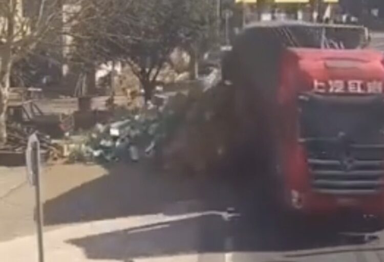 Pessoas se unem para ajudar motorista após caminhão perder carga na China